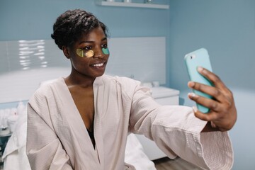 African American woman taking selfie in salon