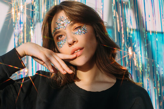 Lovely teenager with stylish make up among tinsel