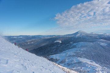 Obraz premium Tourists with a dog travel in a blizzard and bad weather in the mountains
