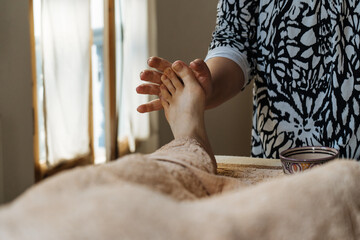 Unrecognizable customer getting foot massage at beauty salon