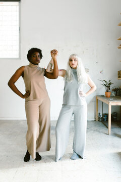 interracial portrait of two empowered and feminist women holding hands.