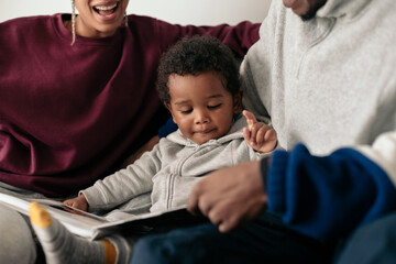 Young parents reading a book with their son