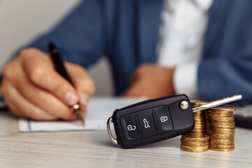 Rental agreement for a car with contract, pen and key close-up. Concept for rental car.