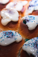 Cinnamon Rolls o Rollitos de Canela caseros rellenos con azúcar de color azul y cubiertos por una capa de glaseado con unas bolitas de azúcar de color azul por encima