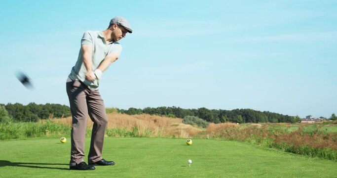 Luxury hobby. Young golf player playing at outdoor course, hitting ball