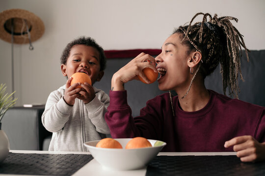 Mother and son playing with oranges