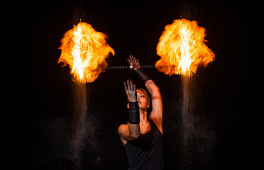 Sensual fire actress manipulate flaming baton in night darkness outdoors, theatre