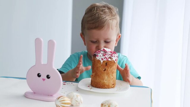 Little boy eating Easter cake. Kid celebrating easter 