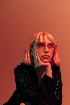Cool young woman in orange light