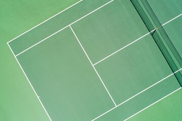Aerial views of green surfaced outdoor tennis hardcourt in summer