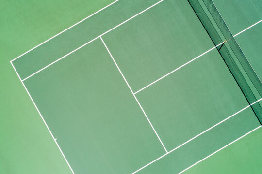 Aerial views of green surfaced outdoor tennis hardcourt in summer