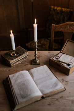 Still life of old books and candles on a wooden table
