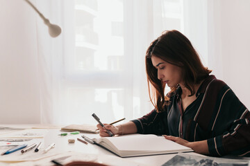 Young woman drawing at home