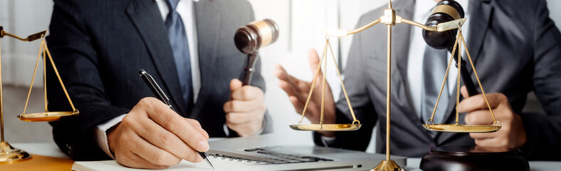 Justice and law concept.Male judge in a courtroom with the gavel, working with, computer and...
