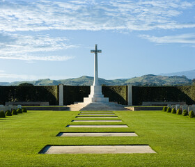 White Marble Cross, Green Grass And Blue Sky With Clouds In Commonwealth War Cemetery - 390218713