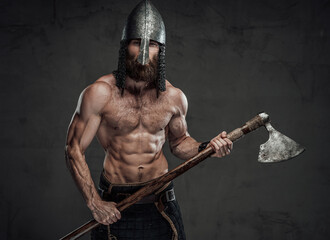 Brutal and muscular northern marauder posing with his two handed axe in dark custom background.
