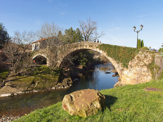 Fototapeta na wymiar The stone bridge of the town of Liérganes crossing the river