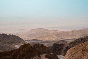 Midlle east nature. An endless narrow road between the mountains. A lonely tiny empty road in the middle of Jordan desert.