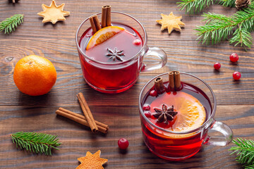 Christmas eve atmosphere with two glass mugs of red tea or mulled wine on brown wooden table