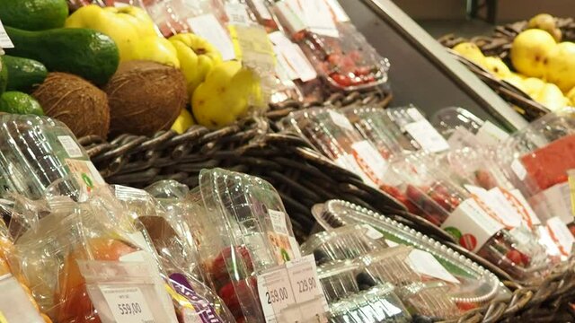 fruits and dried fruits in the store, in packaging, a woman chooses Supermarket , fruit and vegetable zone.