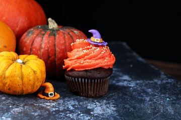 halloween cupcake and pumpkin on a dark background. sweets with cupcakes for the celebration of spooky Halloween.
