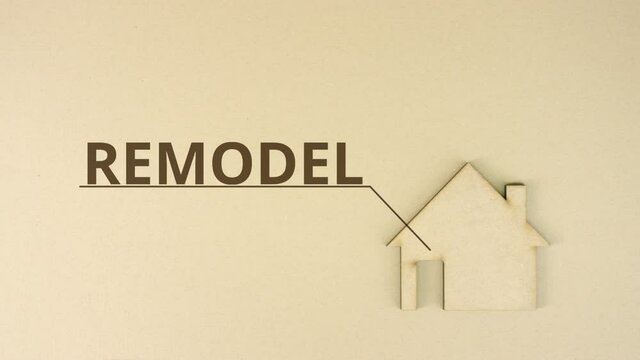 Cardboard home icon with REMODEL text on the table