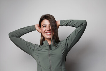 Happy woman doing sport exercise at home, smiling and posing over white wall.