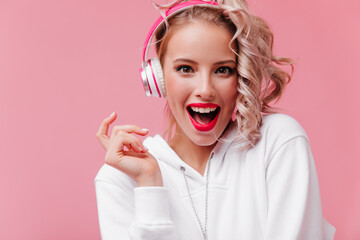 on isolated pink background, bright fair-haired girl, with nude make-up, dressed in white hoodie...