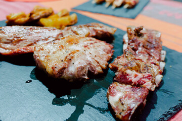 freshly cooked barbecued pork accompanied by deluxe French fries on a black slate plate