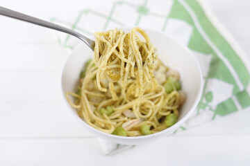 Pasta with pesto and shrimps on a white background