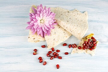 Fresh bread and red pomegranate on the table. background of religion, holiday of life