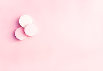 Cosmetic sponges in pastel colors on pink background.