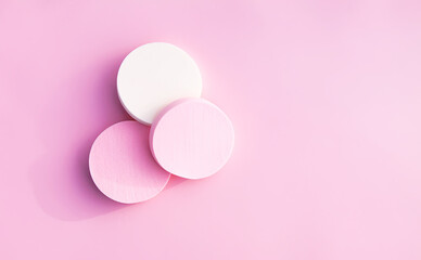 Cosmetic sponges in pastel colors on pink background.