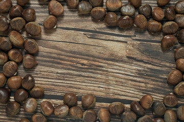 Top view of chestnuts on brown wooden background with copy space for your text.