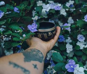 handheld of tibetan singin bowl , plants as background