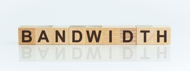 Wooden Blocks with the text: BANDWIDTH. The text is written in black letters and is reflected in the mirror surface of the table.