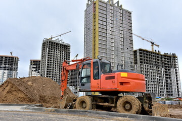 Bucket wheel excavator on earthmoving at construction site. Backhoe digs digs the ground to lay...