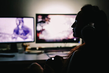 Gamer girl sitting at the monitor at night