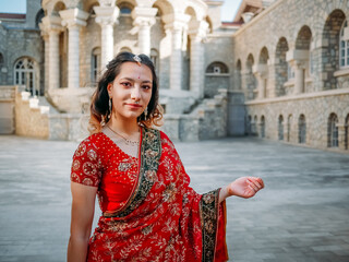 Beautiful ethnic Indian Saree. Young woman in red, colorful, sensual, wedding and very feminine outfit - Indian sari poses on old streets in India. .Traditional national clothing of Indian women