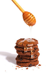honey drains from spoon to cookie. White background