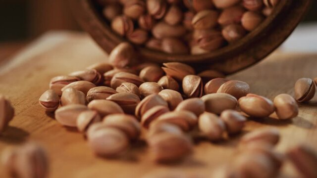 Pistachio kernels and wooden floor pass in front of the camera in slow motion. Macro, 4K, Phantom Camera,Very Close-up, 900 fps video.