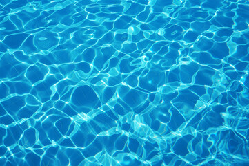Fototapeta na wymiar Beautiful pool with sun glare and reflections on the surface of clear and clear water reflecting on a blue bottom.