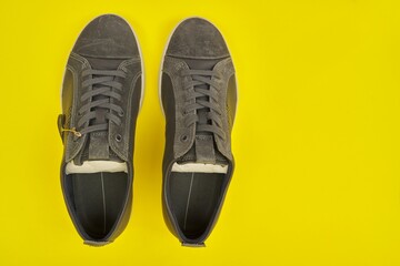 New men's leather gray sneakers on yellow background, top view