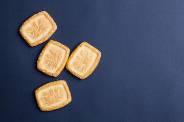Biscuits with sugar on dark background, flat lay with copy space