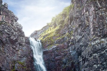 Fototapeta na wymiar Waterfall falling from high rocks in Fulufjallet Nature Reserve