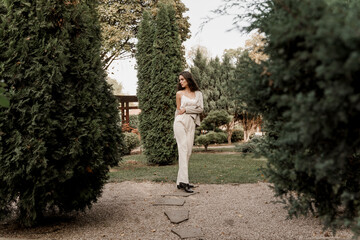 Lifestyle of young business woman. Smiley girl in the green park. Happy young woman walks around green garden.