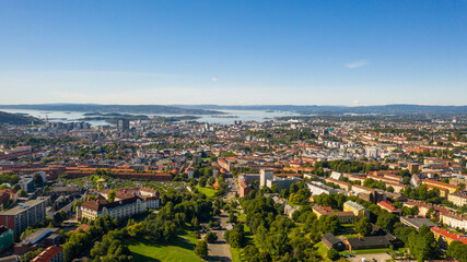 Oslo, Norway. Beautiful panoramic aerial view photo from flying drone for Oslo city center. Against the background of the sea, mountains and blue sky on a sunny summer day. (Series) - obrazy, fototapety, plakaty