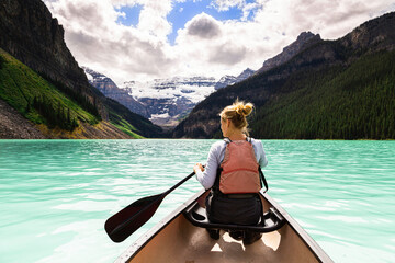 Young beautiful woman kayaking on the Lake Louise, Canada. Concept about leisure, nature, travel and lifestyle. 