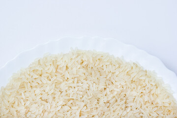 Long grain parboiled rice on white plate close-up. Cereal diet concept. Copy space, top view