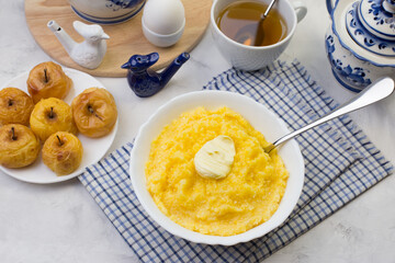 Delicious and healthy Breakfast with corn porridge and baked apples.